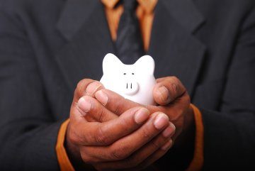 A man holds a small piggy bank